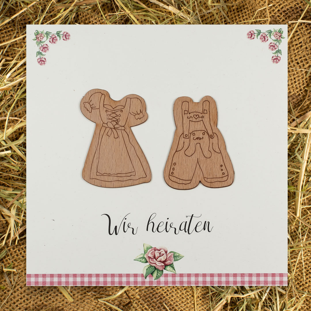 Trachten-Hochzeitseinladungen – vergrößerte Abbildung Einladungen zur Trachtenhochzeit vor Heuhintergrund.
