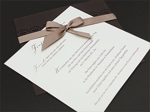 Der Einleger – vergrößerte Abbildung Der Texteinleger der Hochzeitseinladung, schräg unter die Satin-Schleife geschoben.